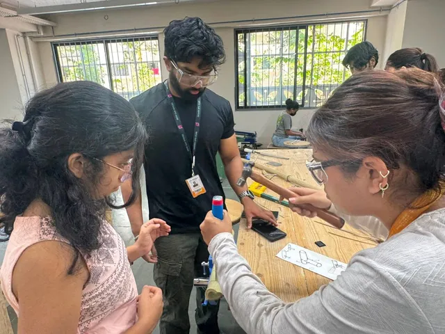 Pranshu with two interns working on bamboo at a workshop table